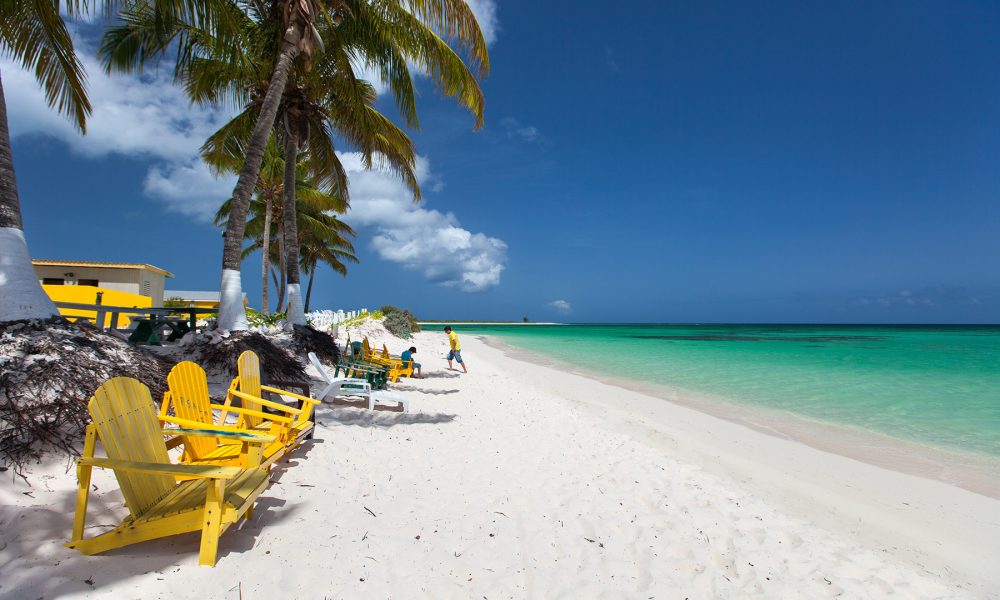 Beautiful tropical beach at Caribbean Beautiful tropical beach with palm trees, white sand, turquoise ocean water and blue sky at Anegada, British Virgin Islands in Caribbean